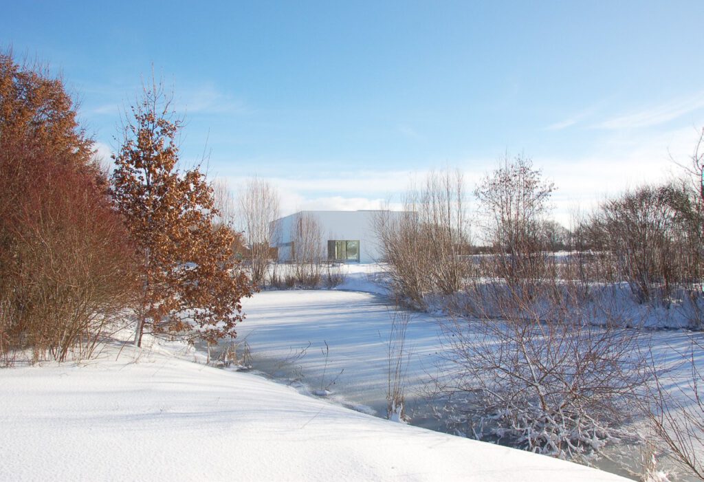 Haus Habla Ingolstadt – Winteransicht über die verschneite Uferböschung