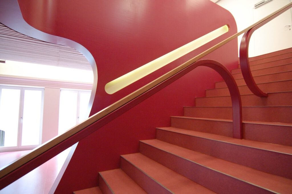 Schülermensa Ingolstadt – Blick über den Lichthandlauf die Treppe abwärts